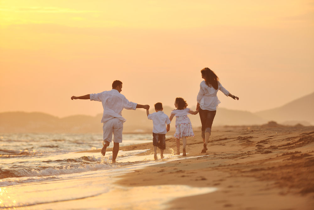 happy young family have fun on beach run and jump at sunset-1